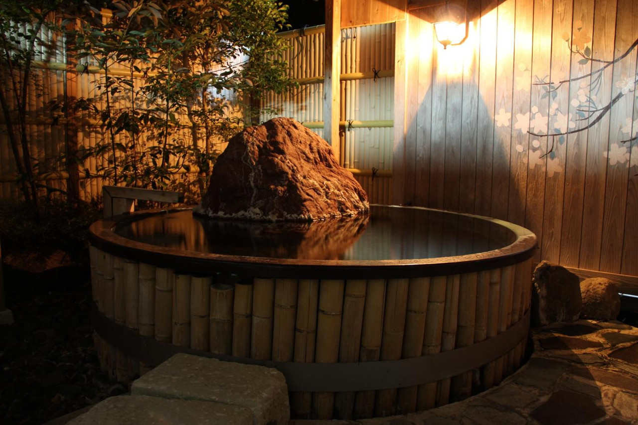 Open-air bath with a stone feature.