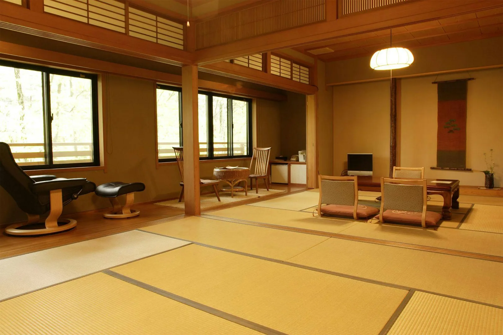 Spacious tatami room at Oyado Nagomino with double-height ceilings and forest windows in Azumino