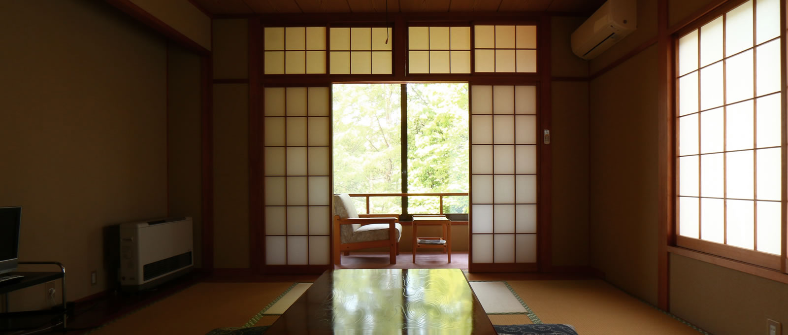 Tatami guest room facing a window-side seating alcove.