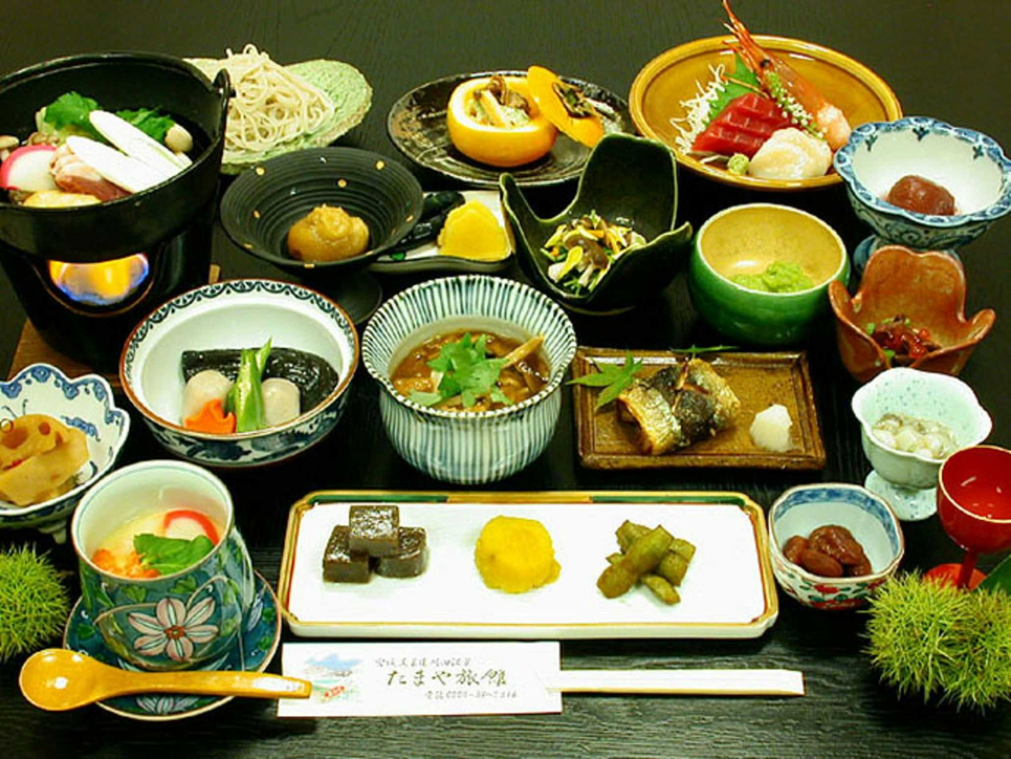 Togatta Onsen Tamaya Ryokan with a traditional Japanese dinner arranged across colorful ceramics.