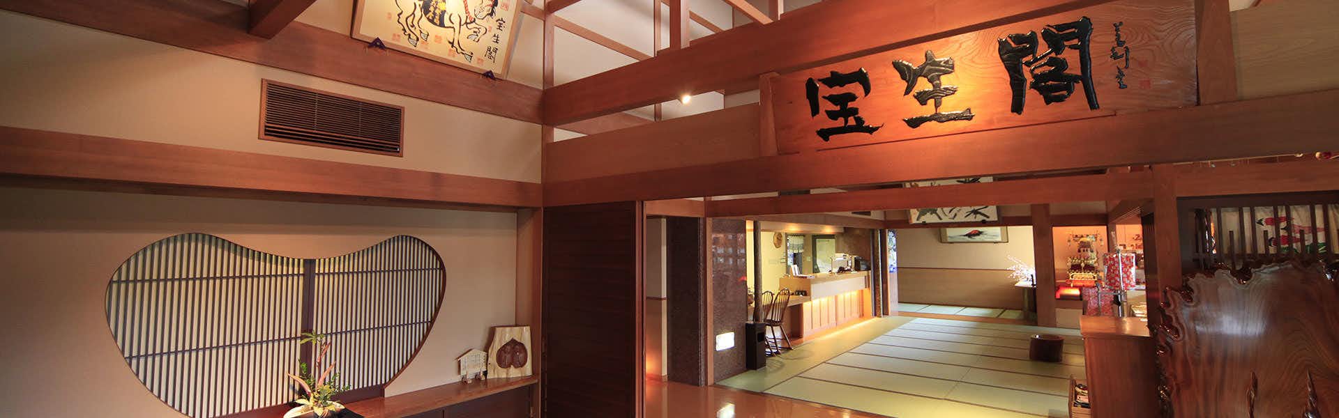 Houshoukaku with the grand timber reception hall beneath red beams and calligraphy.