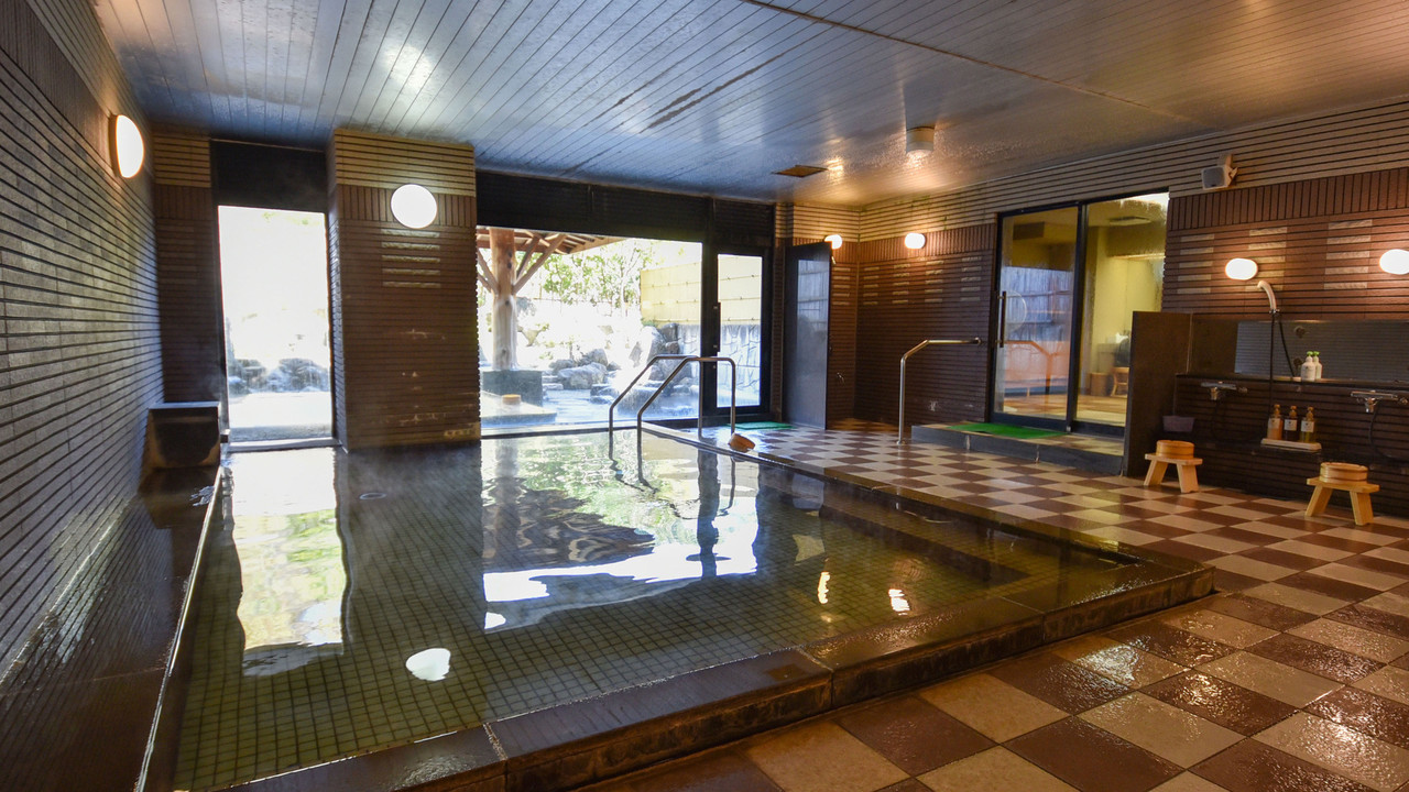 A bright indoor bath combines dark stone and timber.