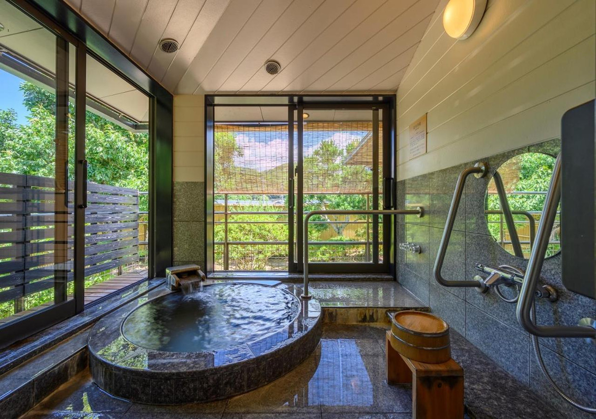 Stone-lined bath beside a green landscape.
