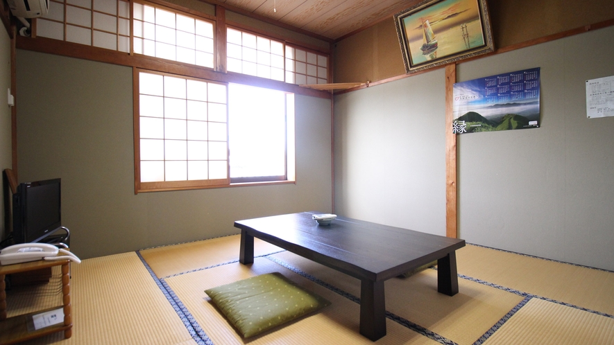 A tatami room with a low table and floor cushions.