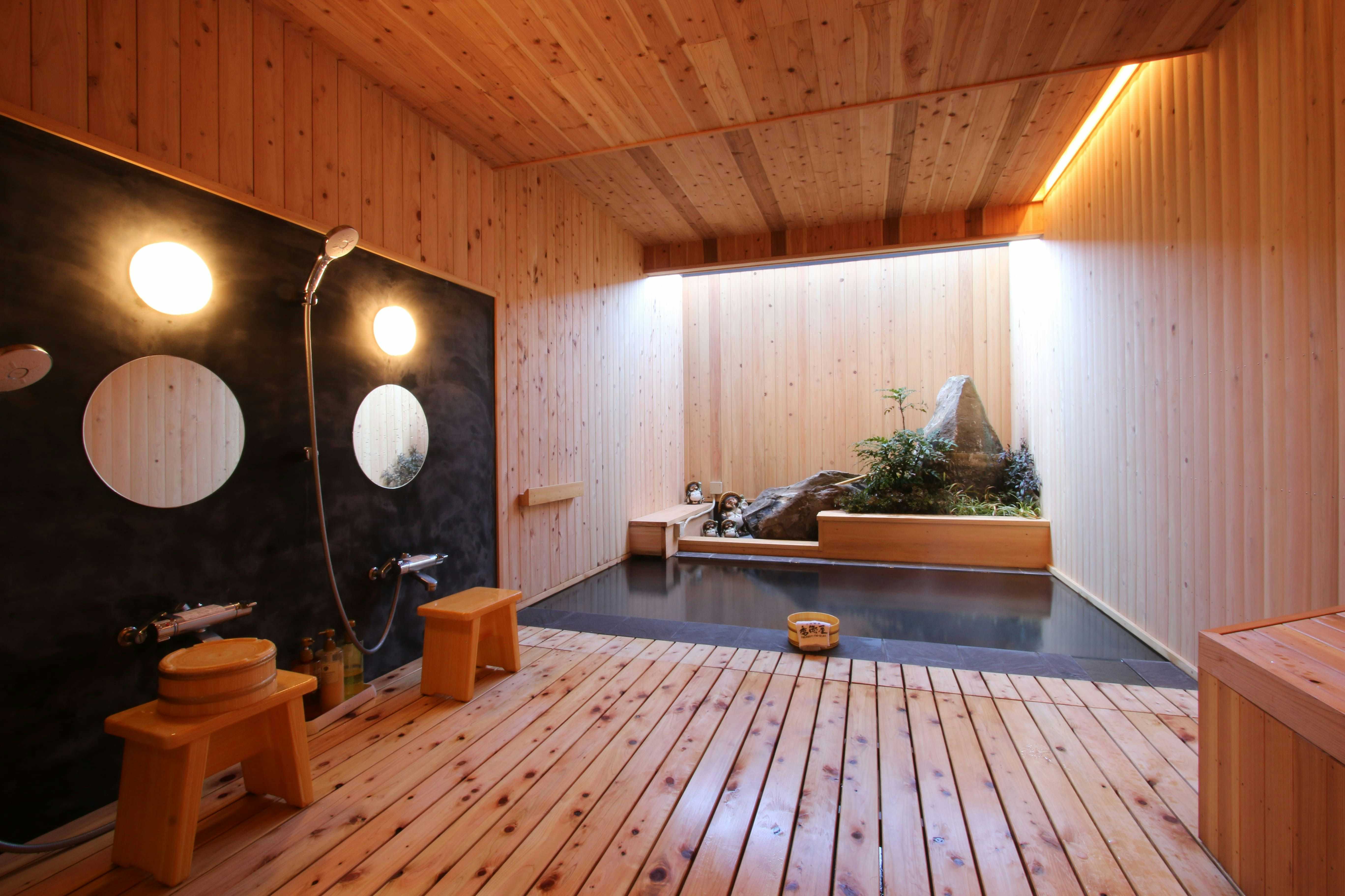 Obama Onsen Fukutokuya Ryokan with a private timber bath with dark circular wall accents.