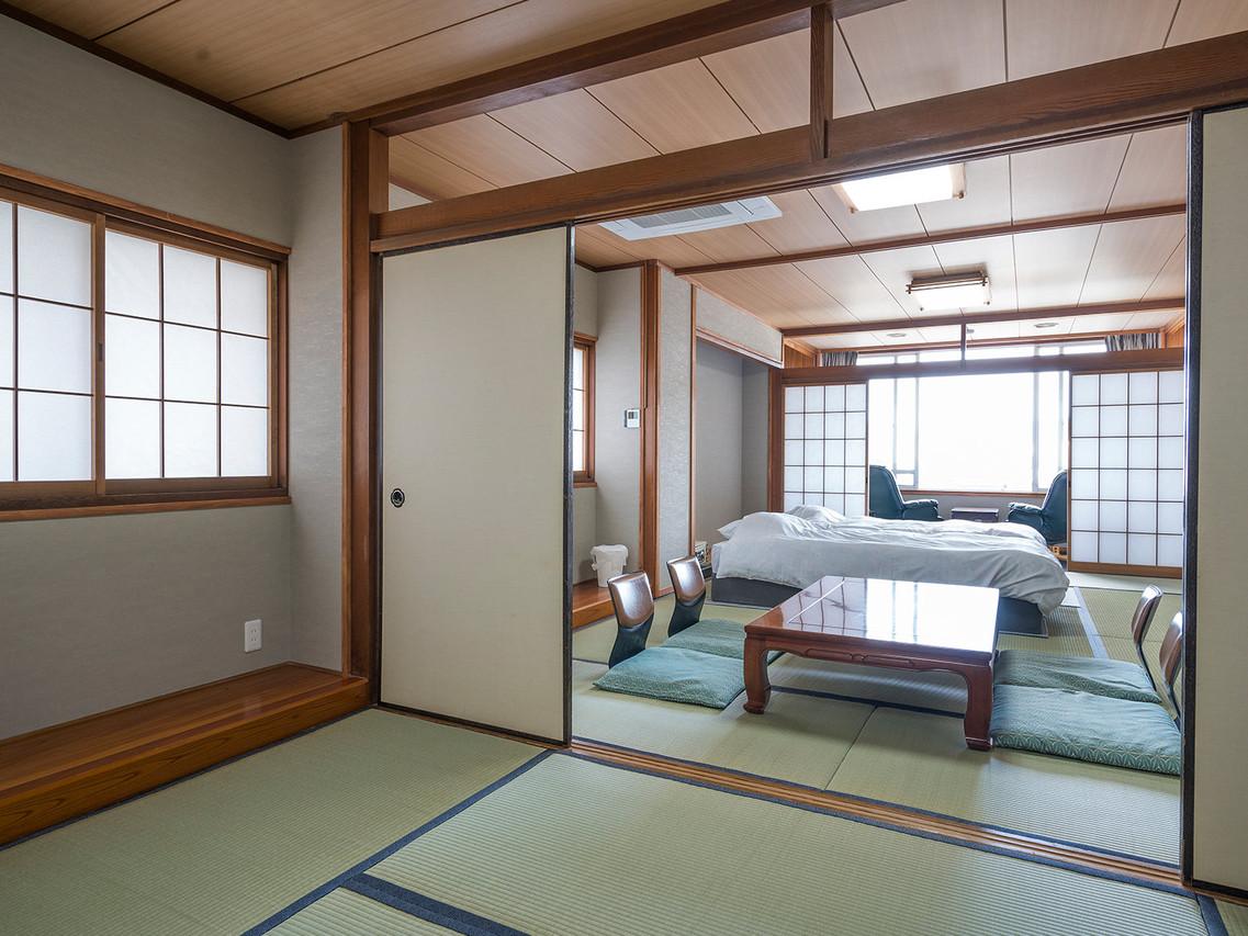 A Japanese-style room with a bed and seating.