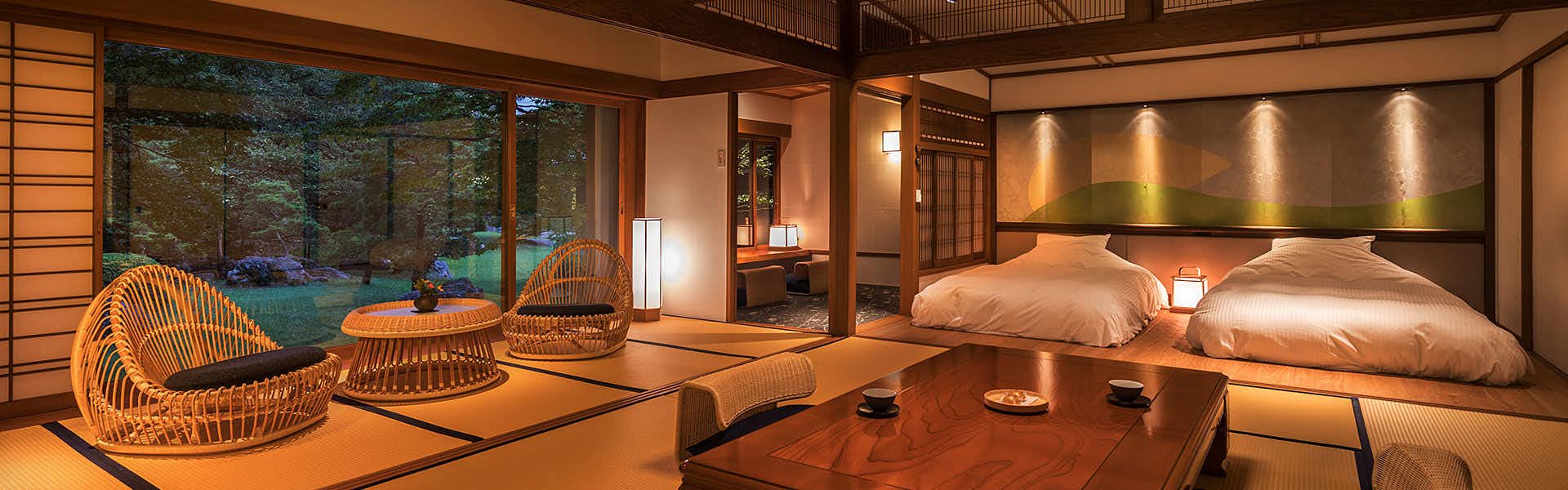 Hotel Parens Onoya tatami bedroom with two beds, woven chairs and broad garden windows