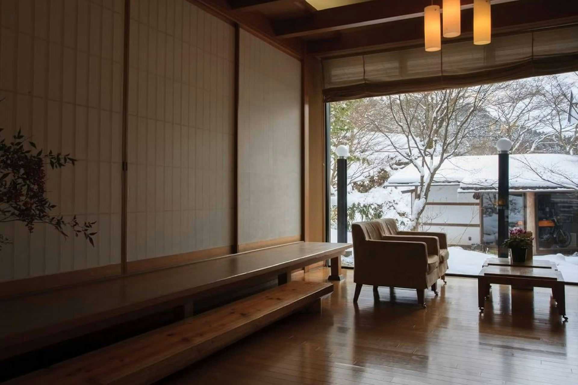 Kisokoma no Yu Onsen - Nukomori no Yado Komano-yu lounge with bench seating facing a snow-covered courtyard