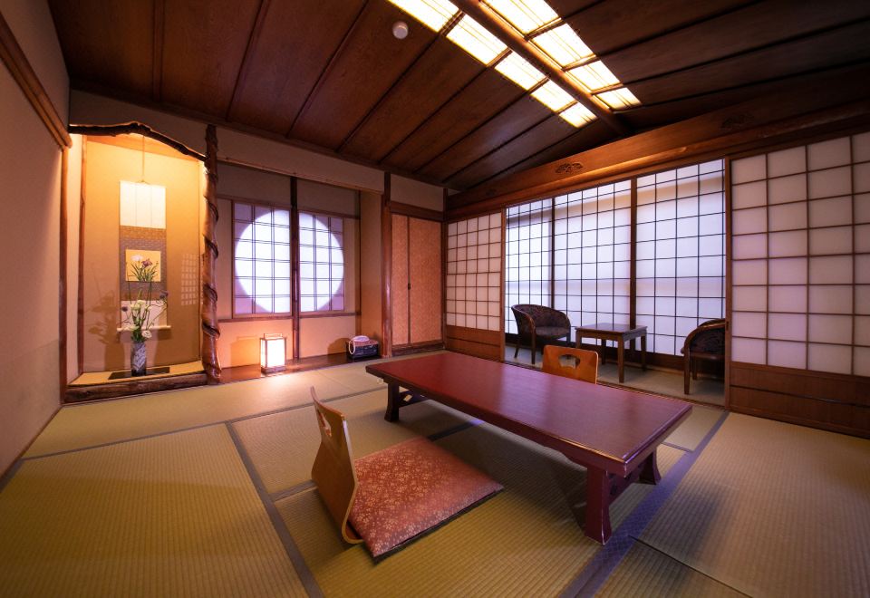 A tatami guest room with a low table and decorative alcove.