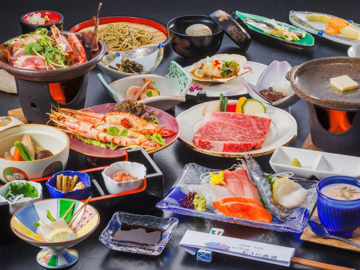 Okina Ryokan with a seasonal dinner arranged across several ceramic dishes.