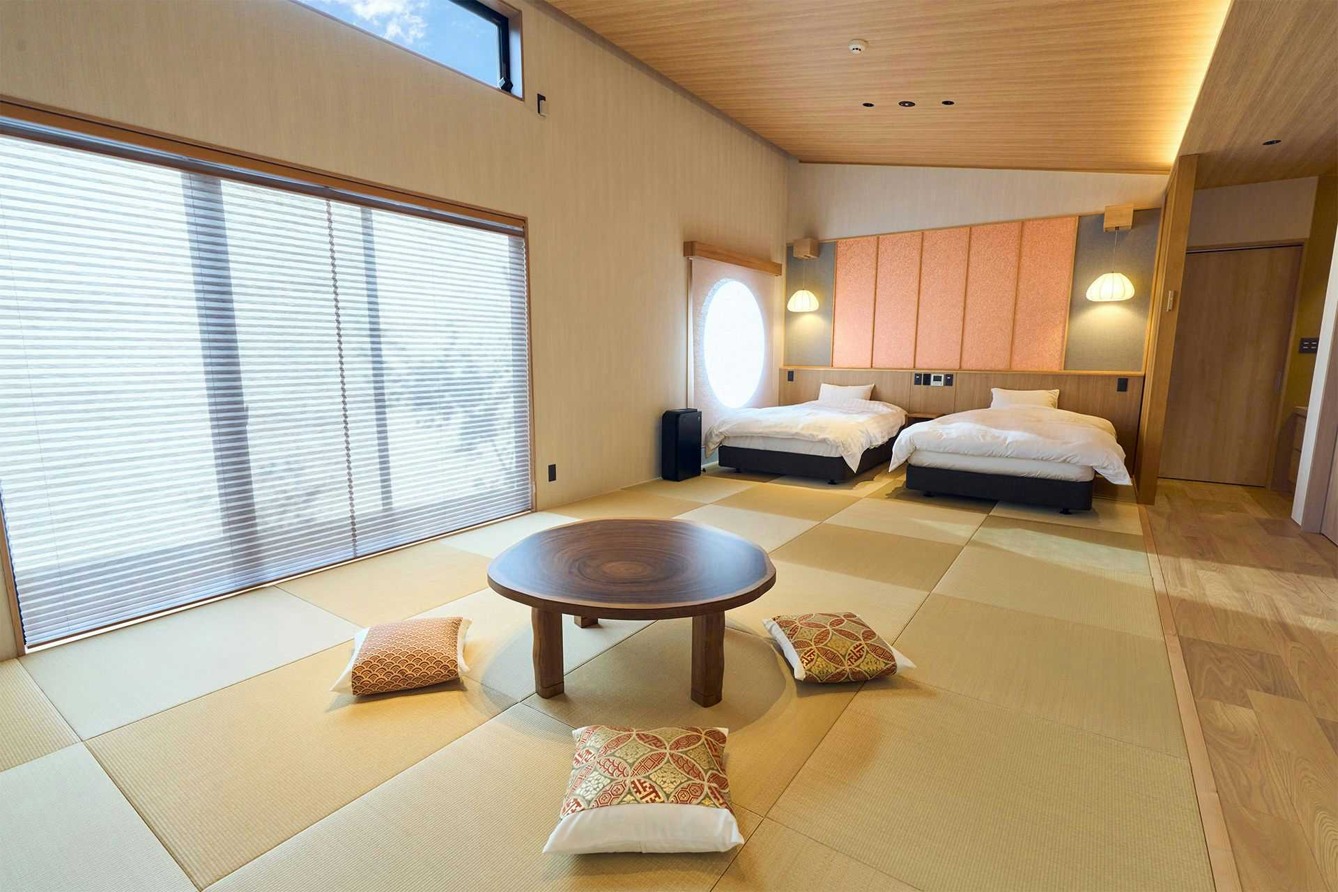 Hitoyoshi Onsen Ishinono-yu Ichifuji Ryokan with a Japanese-Western guest room combining tatami seating and twin beds.
