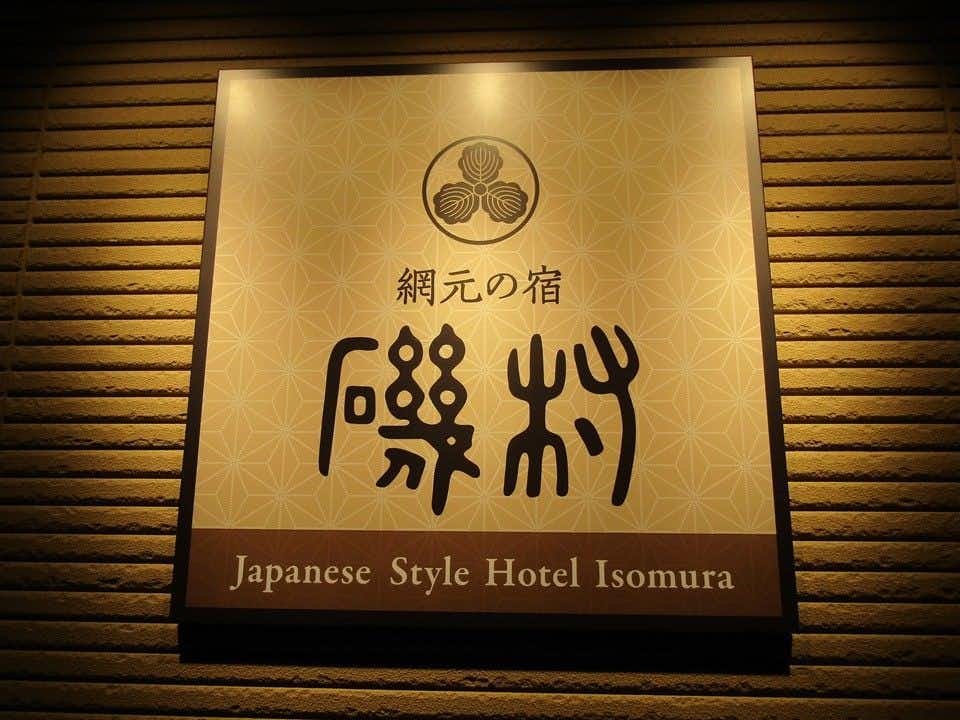 Amimoto no Yado Isomura with a wooden wall sign displaying the inn name.
