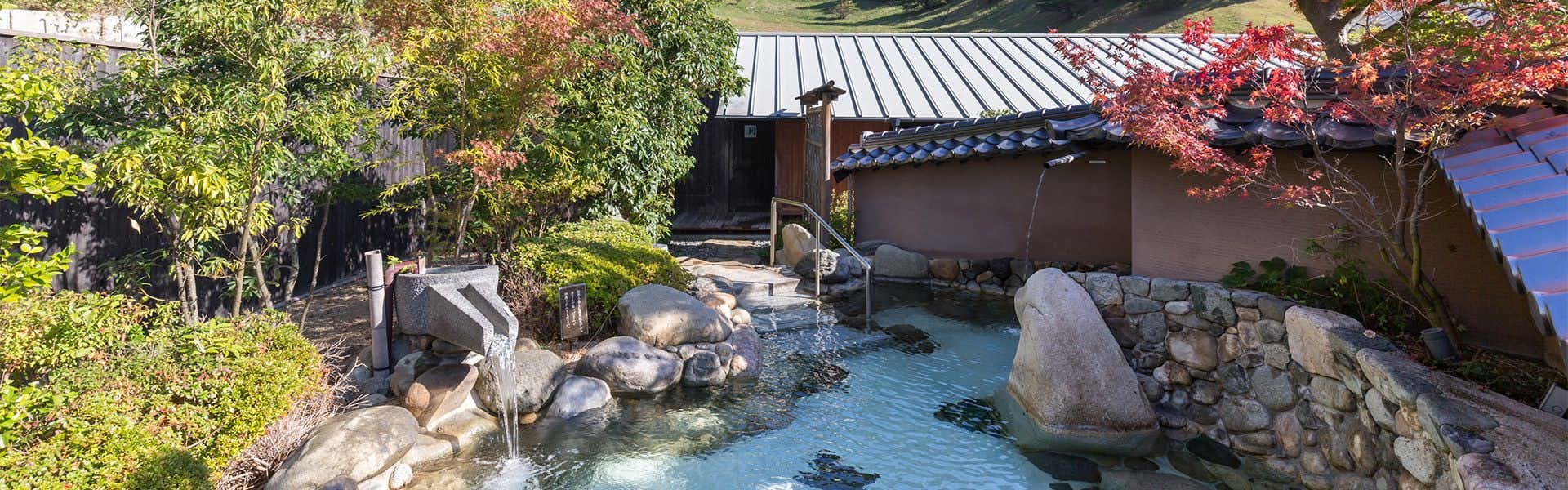 Hagi Honjin with an outdoor rock bath surrounded by autumn foliage.