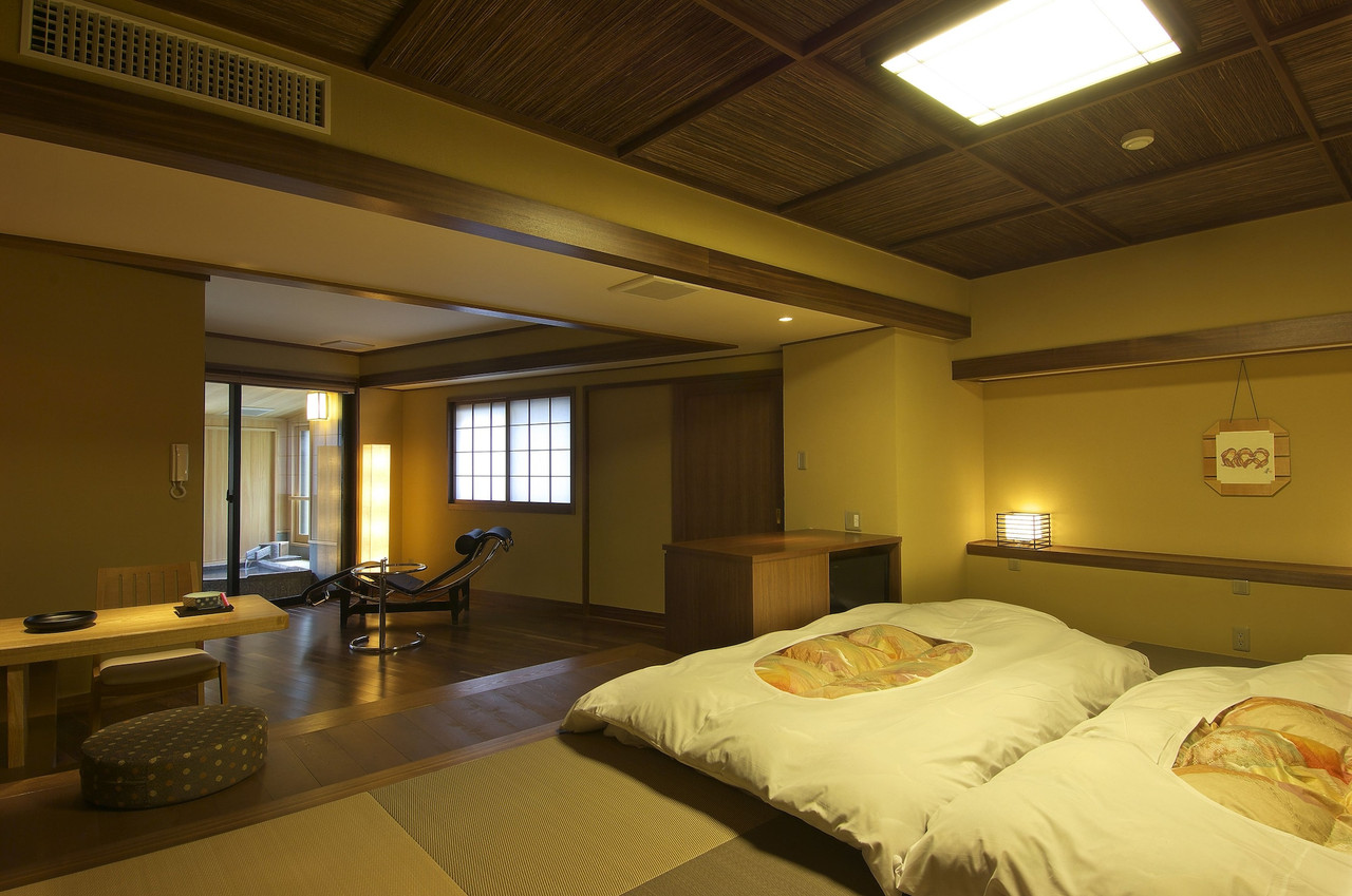 A traditional room is arranged with low seating and bedding.