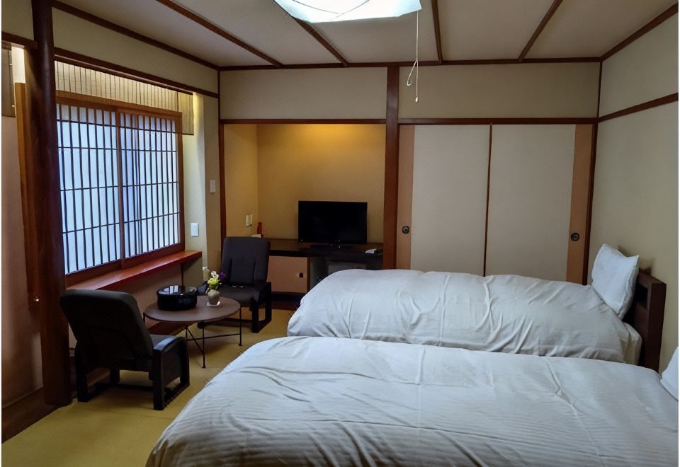 White bedding in a traditional room with a window-side sitting area.