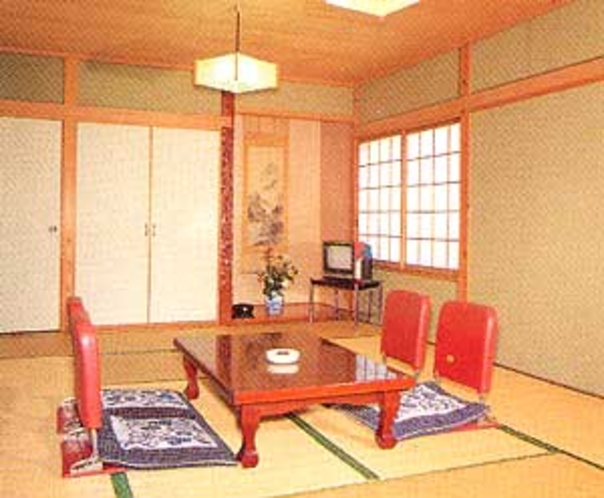 A tatami room with a low table and red floor chairs.
