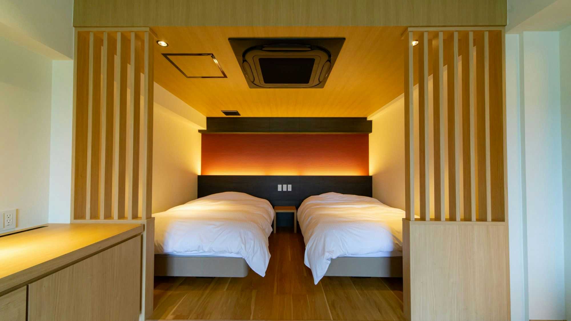 Ryokan Toyotomi with a compact twin bedroom with pale timber floors.