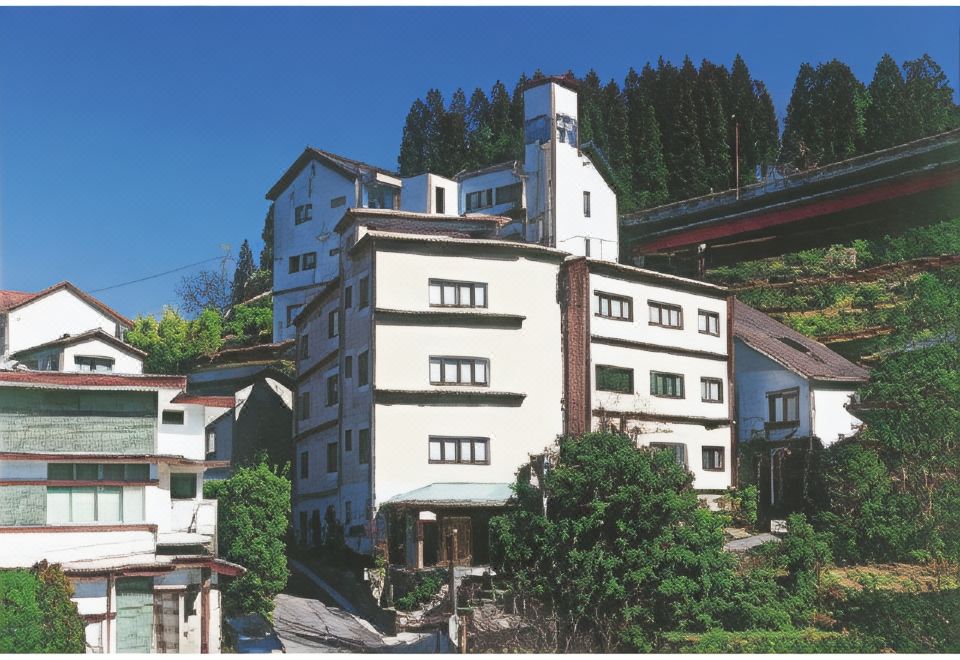 A multi-story hotel building among wooded hills.