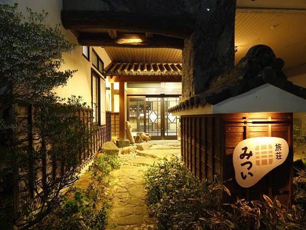 Yuya Onsen Ryosou Mitsui with this scene, where its stone path leads to a lantern-marked entrance after dark.