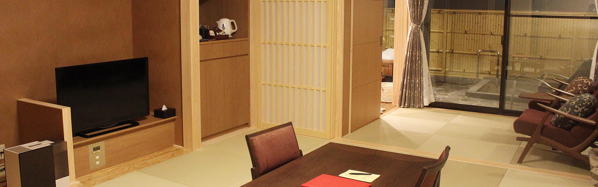 Manten no Yado: All Rooms Equipped with Open-Air Natural Hot Springs with a private stone bath behind broad glass doors.