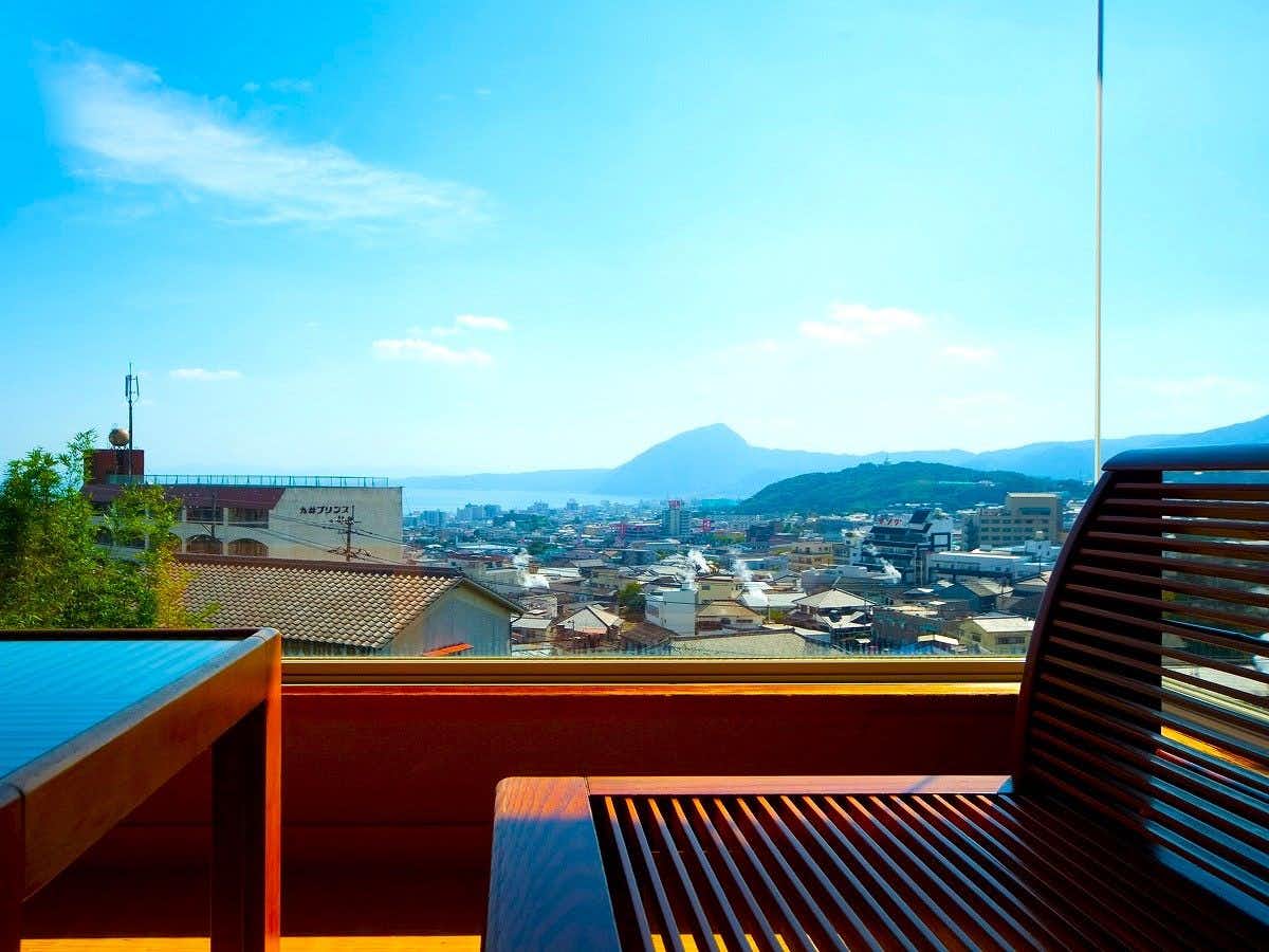 Yukemuri no Sato Azumaya with a timber terrace overlooking the town and distant mountains.