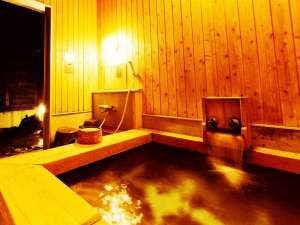 Ryokan Tamano-yu with a private timber bath glowing beneath warm wall lights.