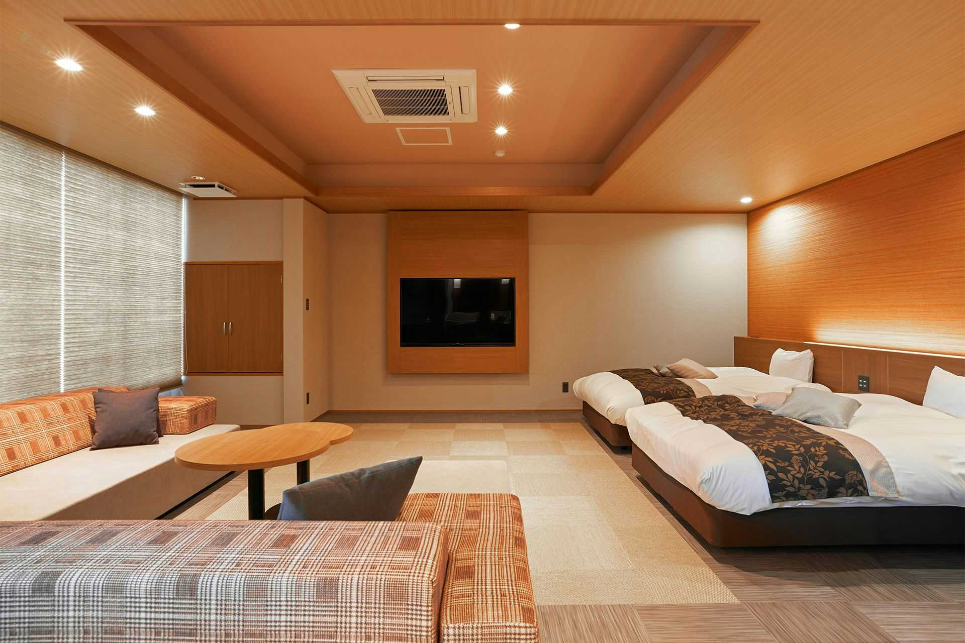Itoyanagi Koyado Yuwa spacious twin-bed room with patterned sofas and a round table