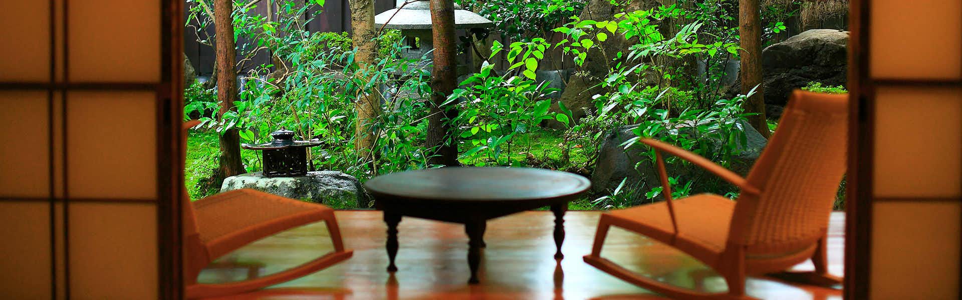 Oyado Hanakanzashi two wicker chairs and a small round table facing a lush garden