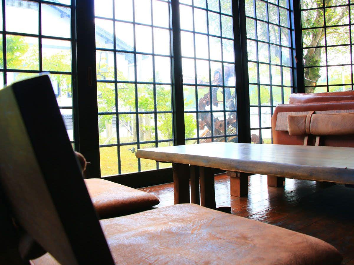 Yunoo Onsen Irori no Yado Ryokan Hayamizusou with a lounge with lattice windows and leather seating around a low table.