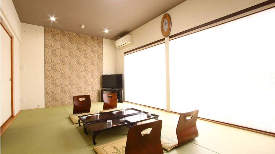 Hinata-ya with a simple tatami room with low table and curtained windows.