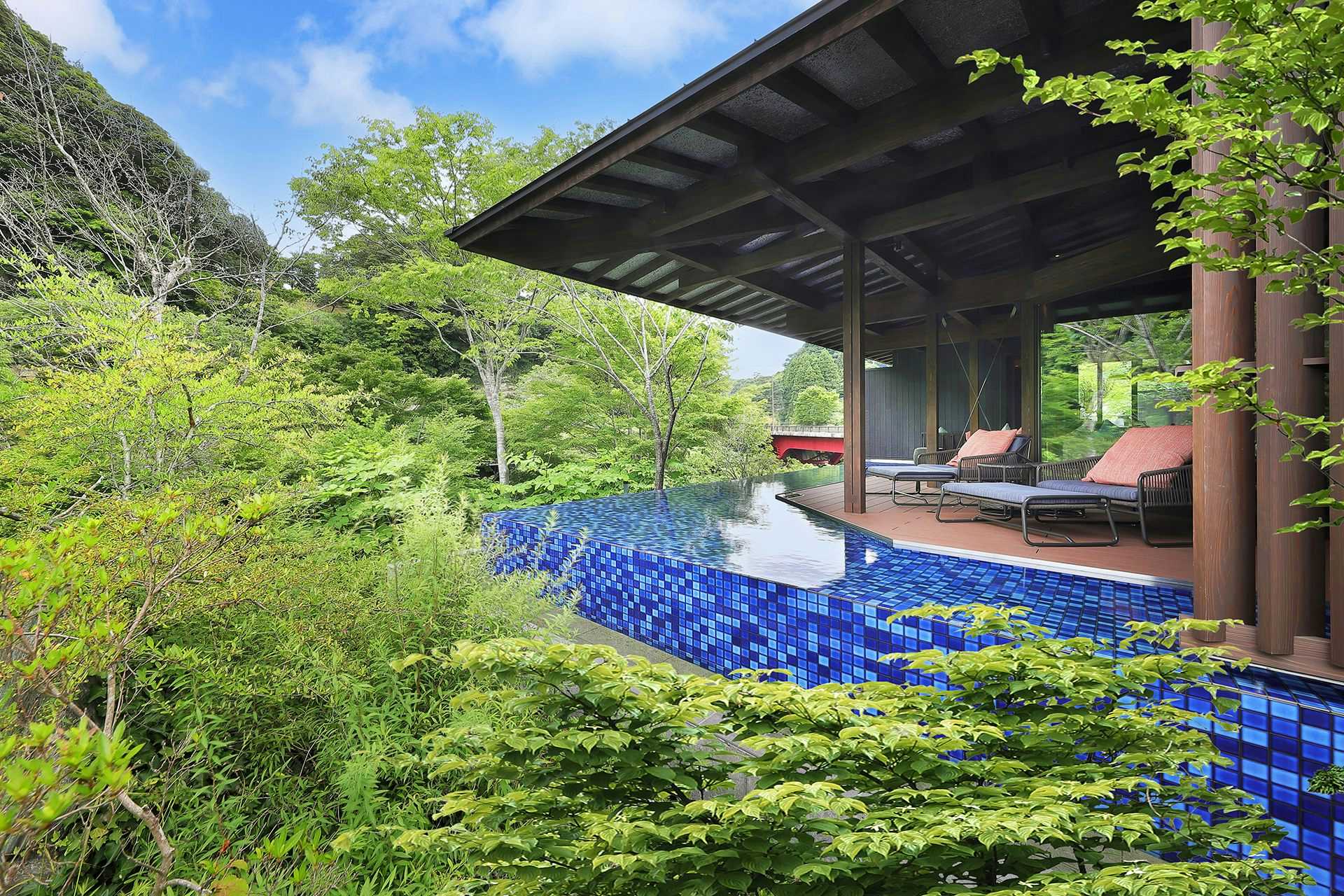 SHINRA YORO VALLEY with a forest pavilion extending over a cobalt blue pool.
