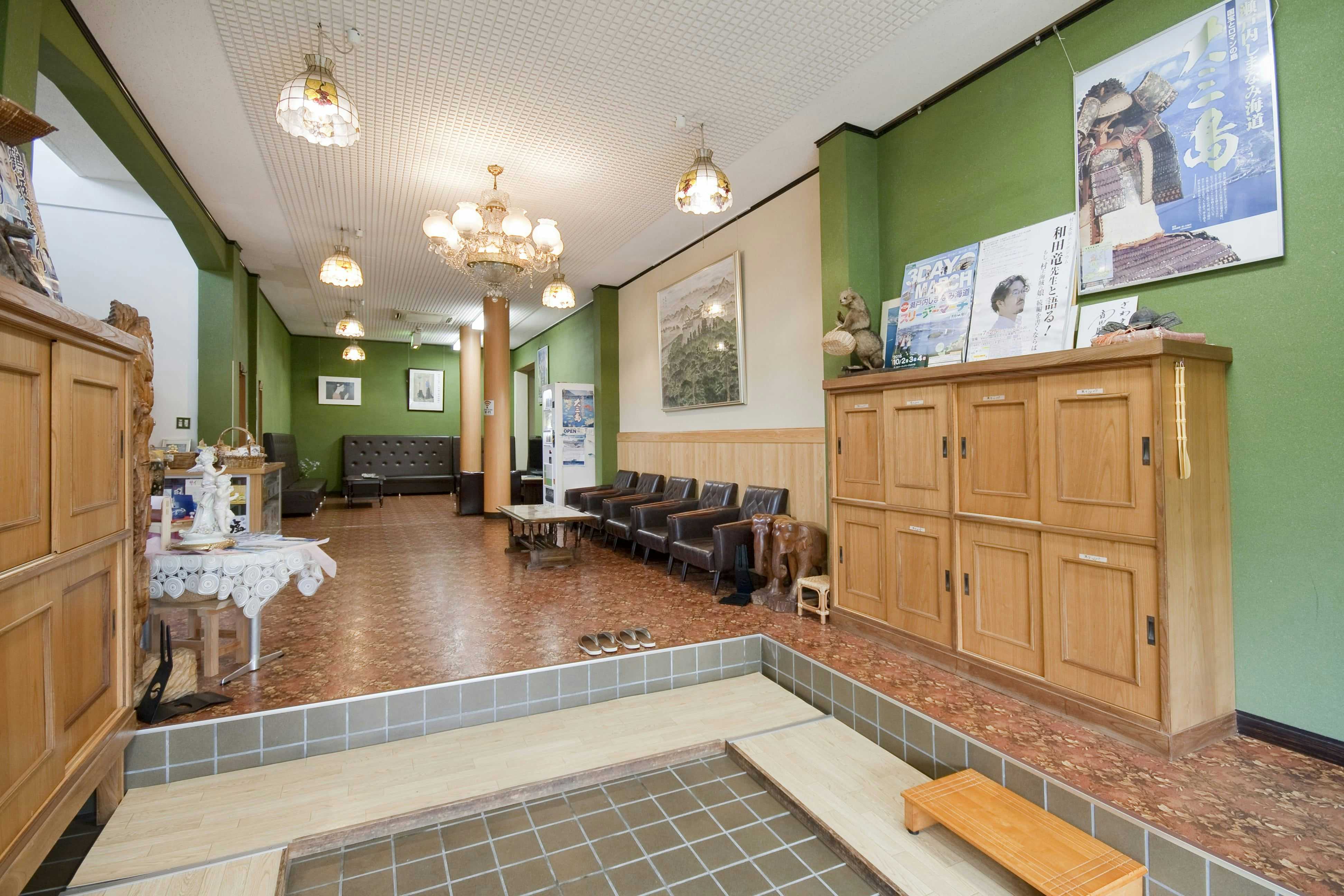 Ryokan Sawaki with a bright reception lobby with chandeliers and timber cabinetry.
