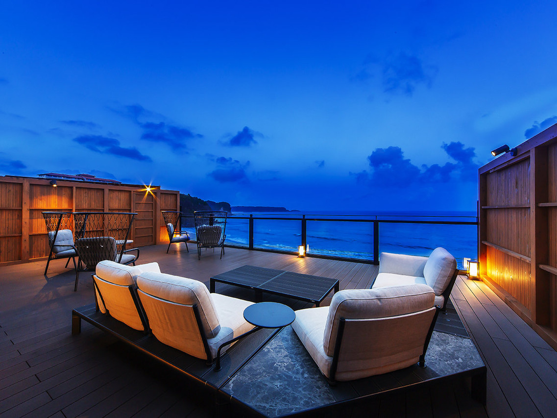 Ocean-facing terrace with lounge chairs.