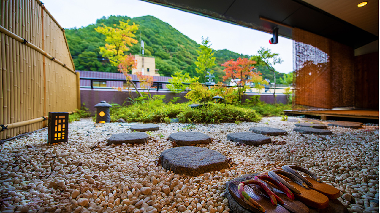 A timber building borders a quiet stone courtyard.