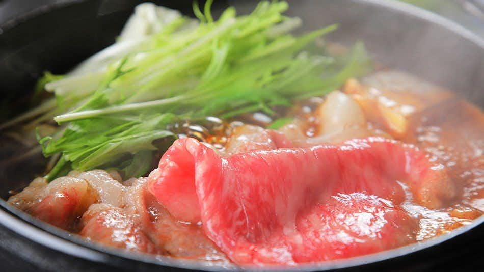 Sakakibara Onsen Ryokan Seishonagon with thinly sliced beef simmering with greens in a black skillet.