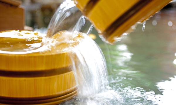 A close view of water flowing from a wooden spout.