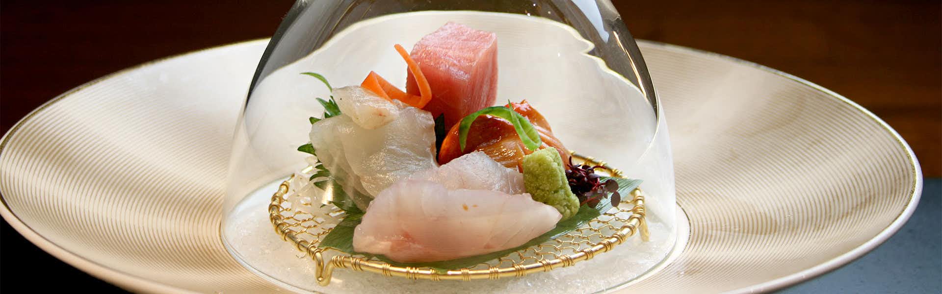 Shiki Yuzawa QUATTRO with this scene, where sashimi and bright garnishes are arranged on a sculptural white plate.