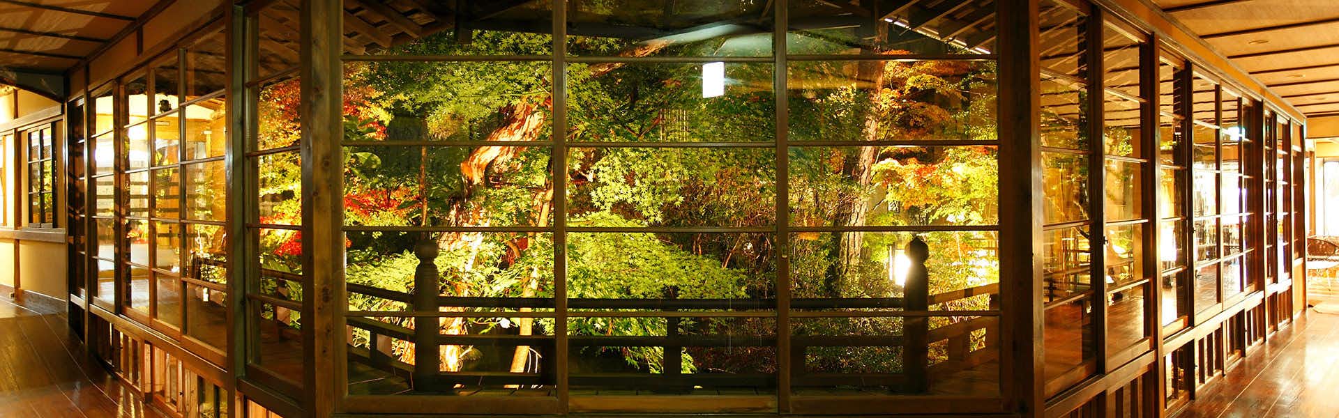 Yumekairo Kikuya (Kyoritsu Resort) with a polished corridor overlooking dense garden greenery.