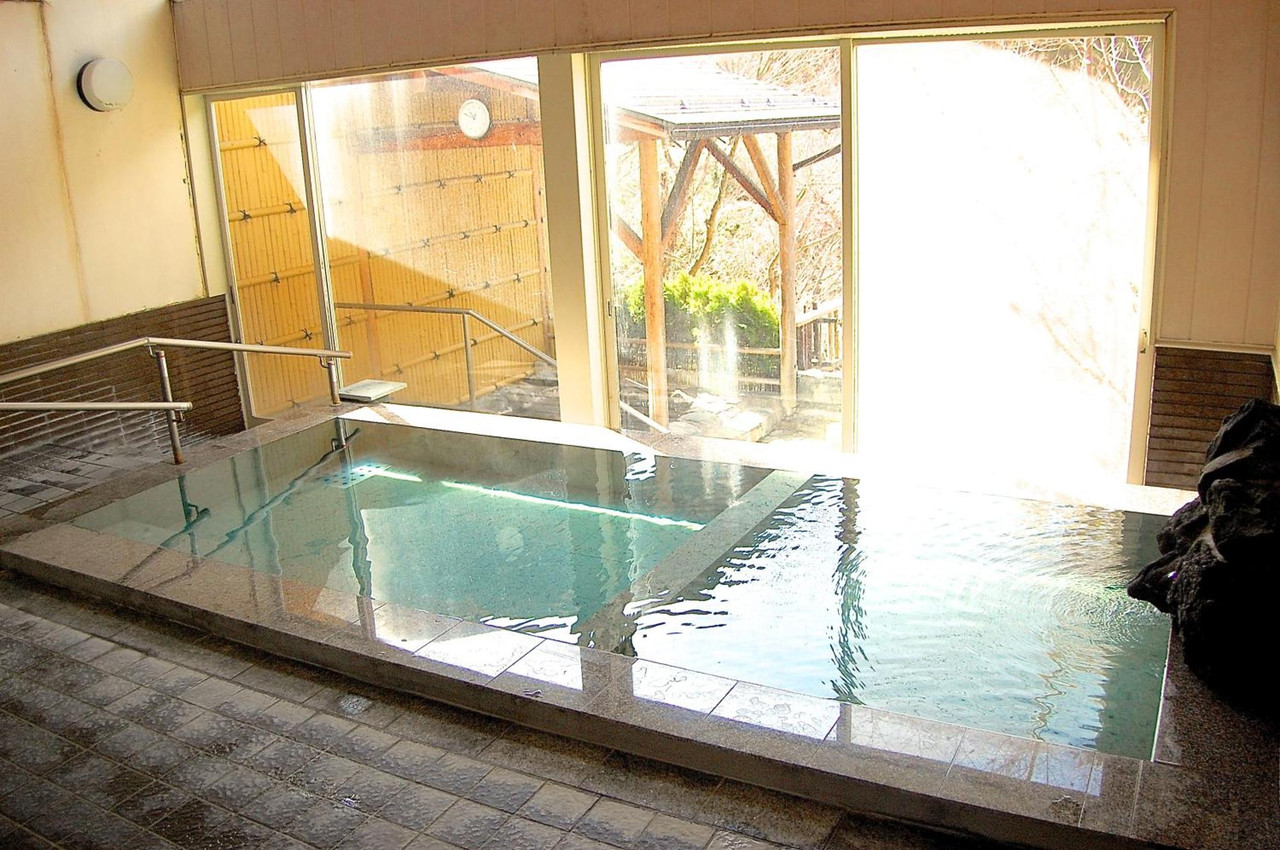 A bright indoor bath beside large windows.