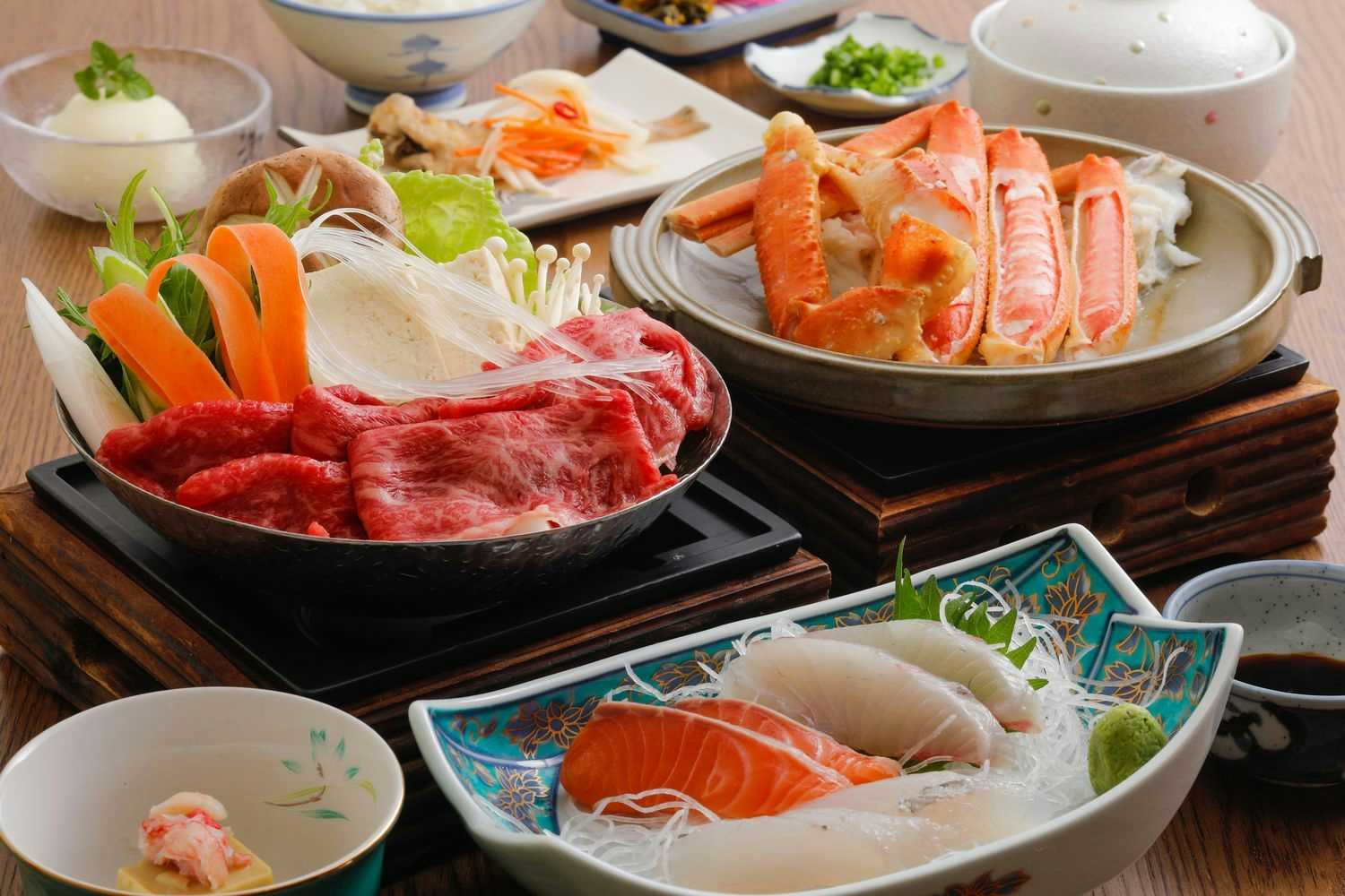 Kinosaki Onsen Tsuruyaryokan with a seafood dinner featuring beef, crab, and sashimi.
