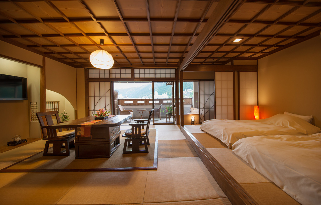 Spacious guest room with beds and shoji screens.