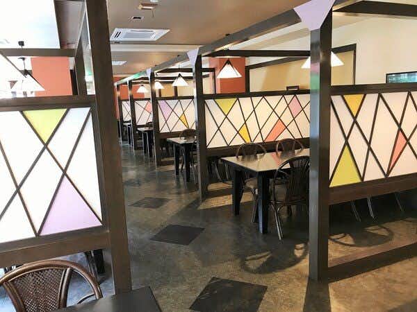 Takimien dining room with colorful geometric screens, tables and upholstered chairs
