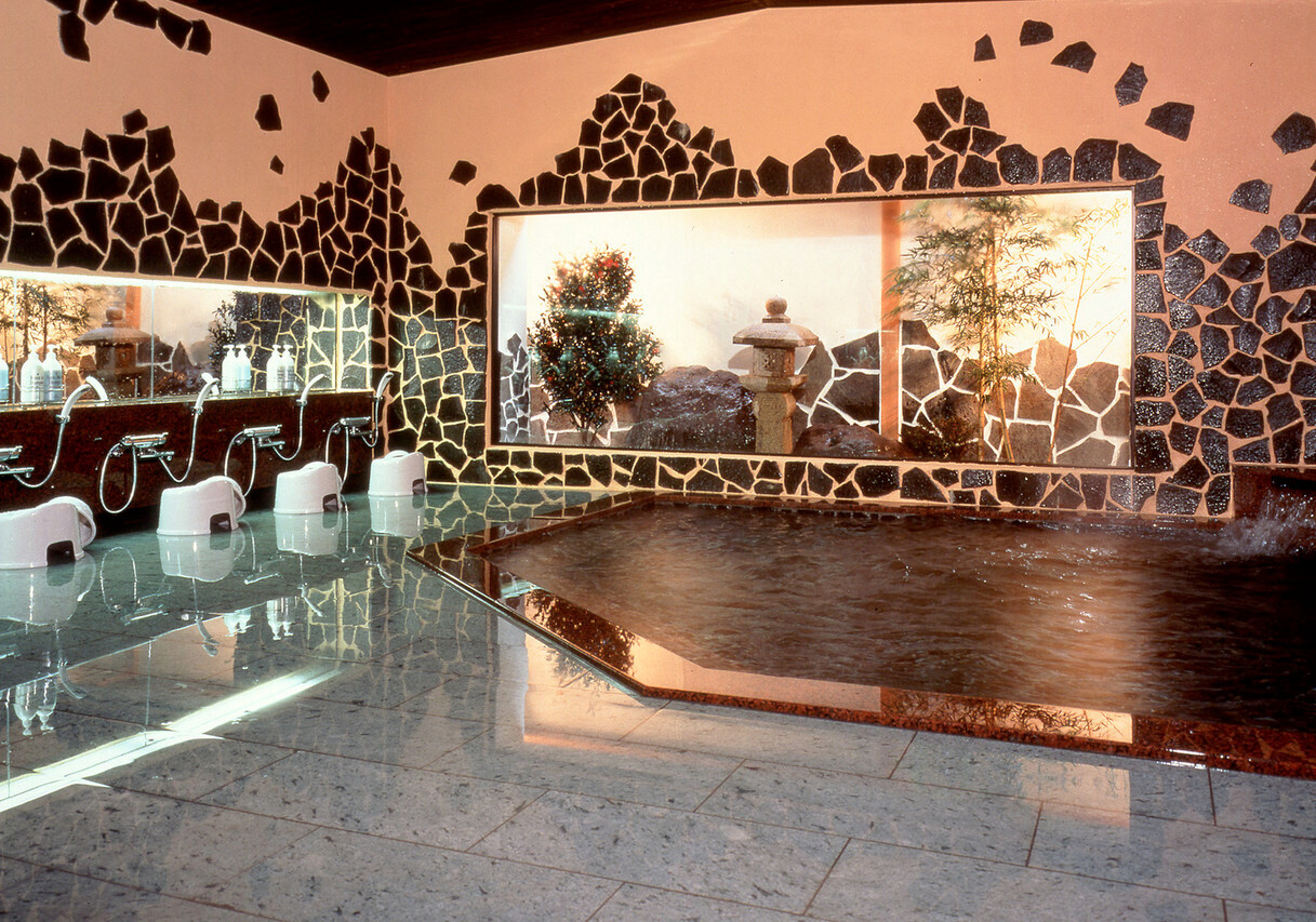 A tiled bath with a decorative wall.