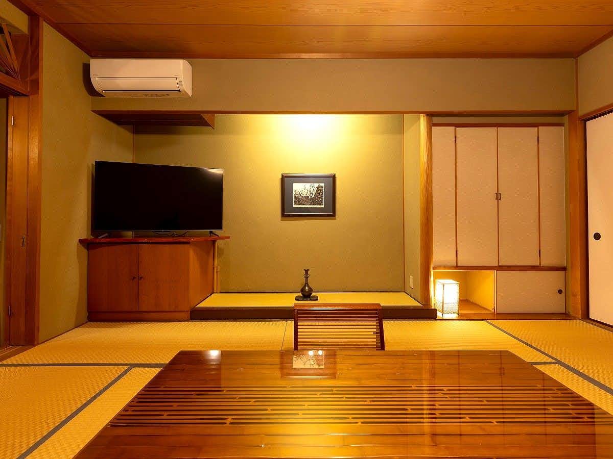 Yukemuri no Sato Azumaya with a warm tatami room with low table and timber flooring.