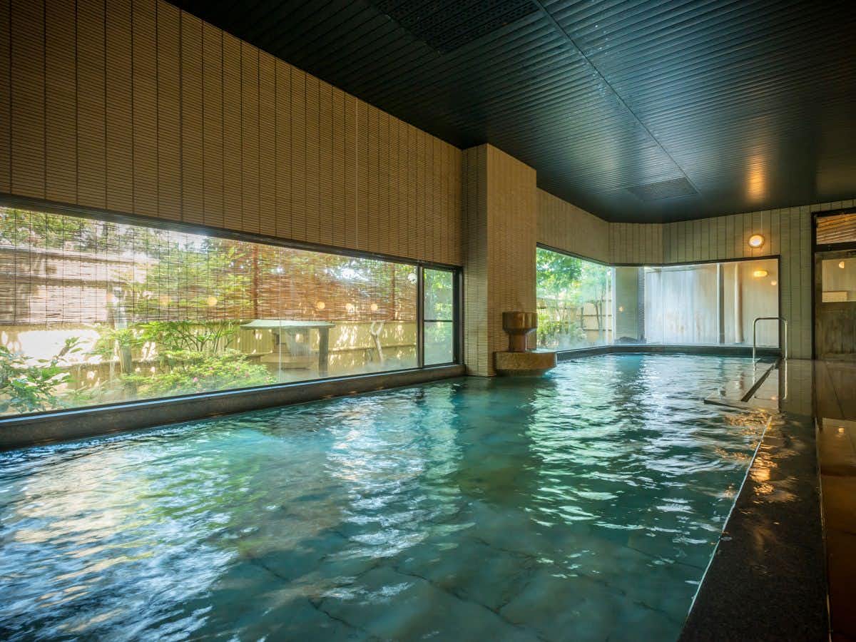 Kanoya Kourakuen with an indoor mineral bath beside garden windows.