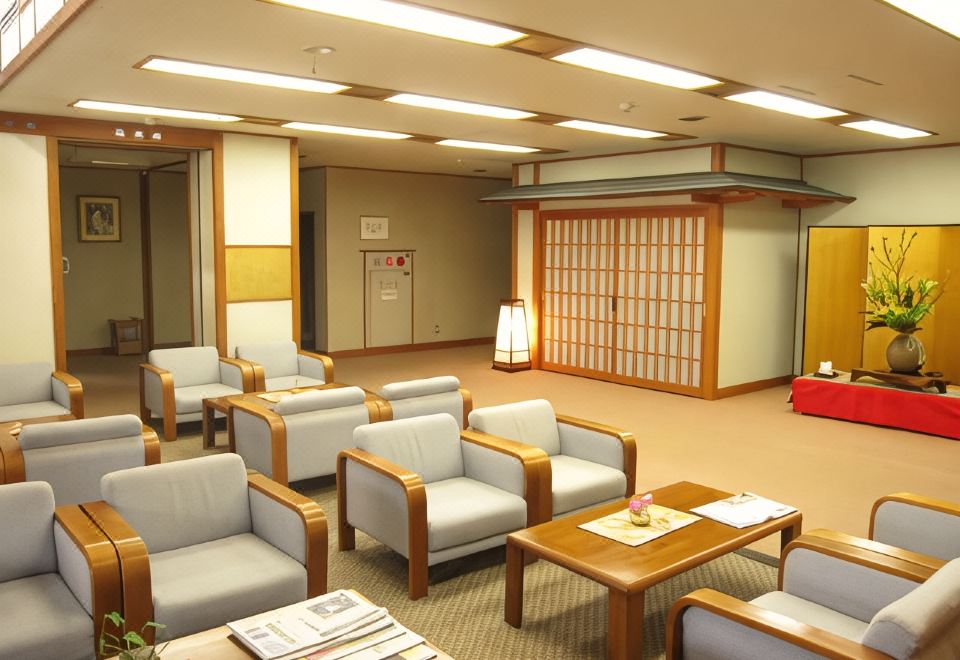 A hotel lounge with armchairs and a low table.
