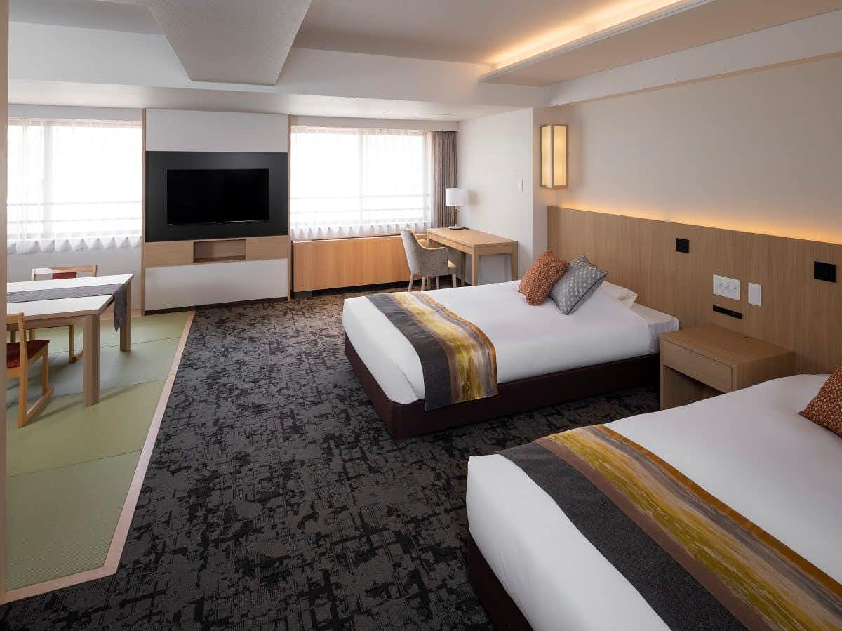 Hotel Yumoto Noboribetsu with a modern twin bedroom with adjoining tatami dining area.