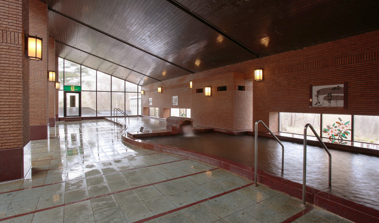 A bright indoor bathing area with windows.