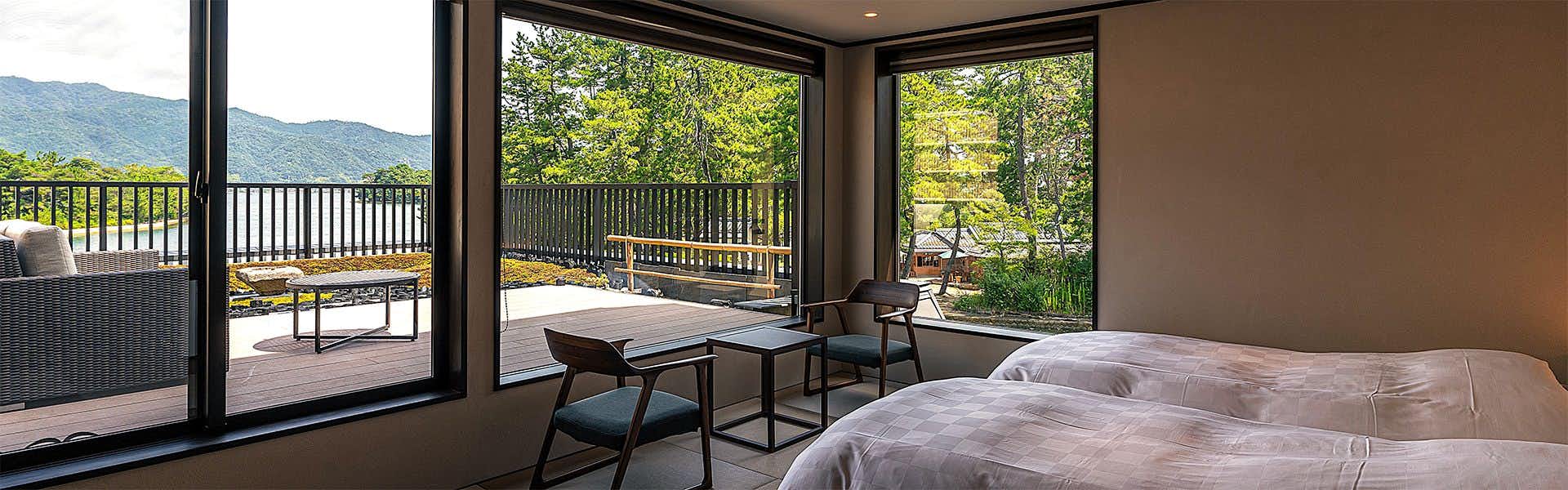 Amanohashidate Onsen Taikyourou with a traditional tatami room with low table and waterfront windows.