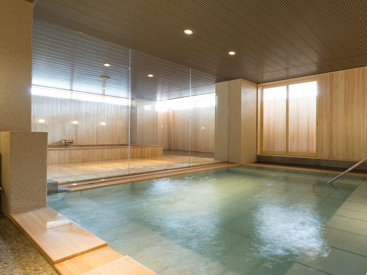 Hotel Kikyou bright rectangular indoor bath with a wood surround and glass wash area
